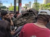 A fan dressed as a dinosaur walks through the crowd as Toronto fans fill the streets in front of city hall during the Toronto Raptors NBA Championship celebration parade at Nathan Phillips Square in Toronto