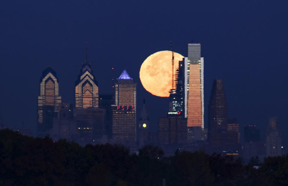 FILE - In this Nov. 14, 2016 file photo a supermoon sets behind the Philadelphia skyline. Bird Safe Philly announced on Thursday, March 11, 2021, that Philadelphia is joining the national Lights Out initiative, a voluntary program in which as many external and internal lights in buildings are turned off or dimmed at night during the spring and fall bird migration seasons. Millions of birds annually migrate through Philadelphia during spring and fall and many are killed when they fly into buildings, confused by the bright artificial lights and glass (AP Photo/Joseph Kaczmarek,File)