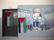 A poster of 17-year-old Palestinian Mohammad Hamayel adorns a door of a classroom, in the village of Beita, south of the West Bank city of Nablus. Monday, June 14, 2021. Hamayel was killed during clashes with Israeli forces following a protest against the wildcat Jewish settlement of Eviatar that was established last month without the permission of Israeli authorities on land the Palestinians say is privately owned. (AP Photo/Majdi Mohammed)