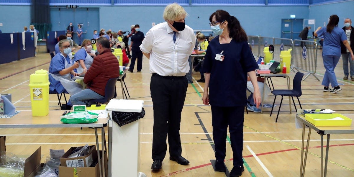 Britain's Prime Minister Boris Johnson speaks with health worker Wendy Warren during his visit at a coronavirus disease (COVID-19) vaccination centre at Cwmbran Stadium in Cwmbran, South Wales, Britain February 17, 2021. Geoff Caddick/Pool via REUTERS