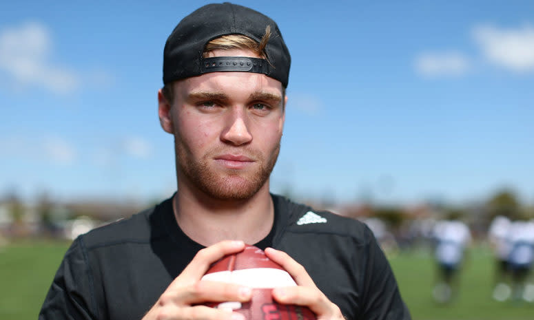 tate martell holds a football during a camp