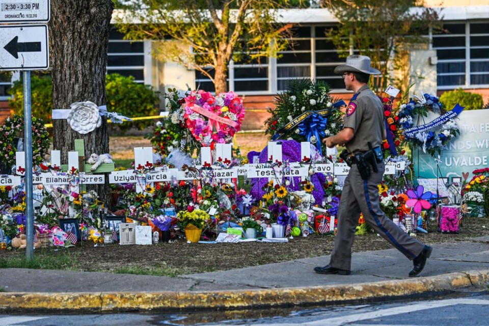 <div class="inline-image__caption"> <p>A police officer walks near the makeshift memorial for the shooting victims outside Robb Elementary School in Uvalde, Texas.</p> </div> <div class="inline-image__credit"> CHANDAN KHANNA / AFP </div>