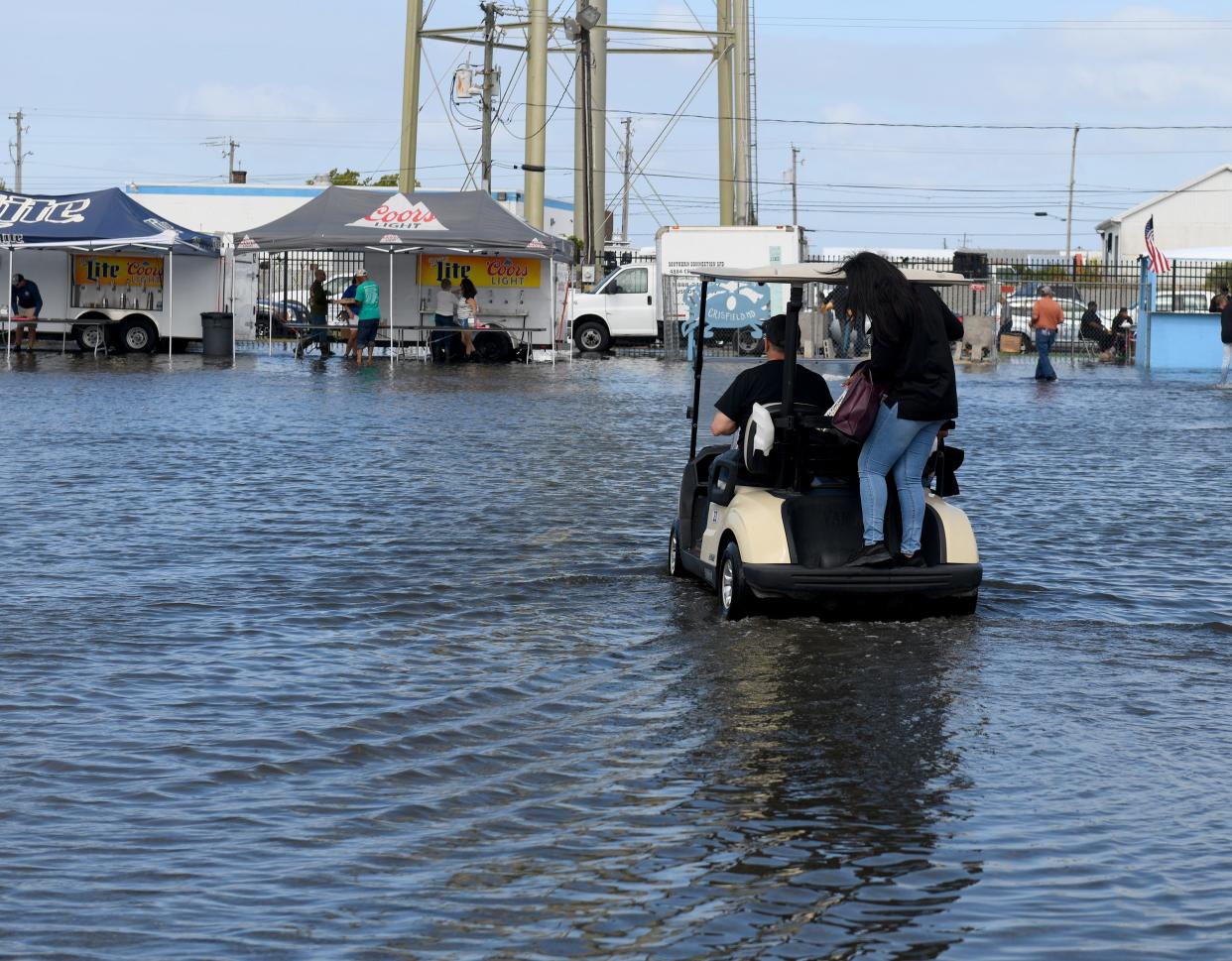 A golf cart drives thorugh the flood waters at the J. Millard Tawes Crab and Clam Bake Wednesday, Sept. 27, 2023, at Somers Cove Marina in Crisfield, Maryland.