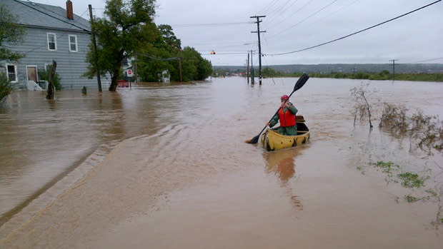 A man flees a flooded home on Highway 311 between Bible Hill and Truro.