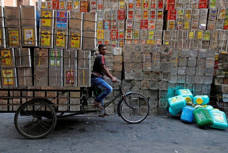 FILE PHOTO: A man pedals a tricycle loaded with empty cooking oil containers in Kolkata