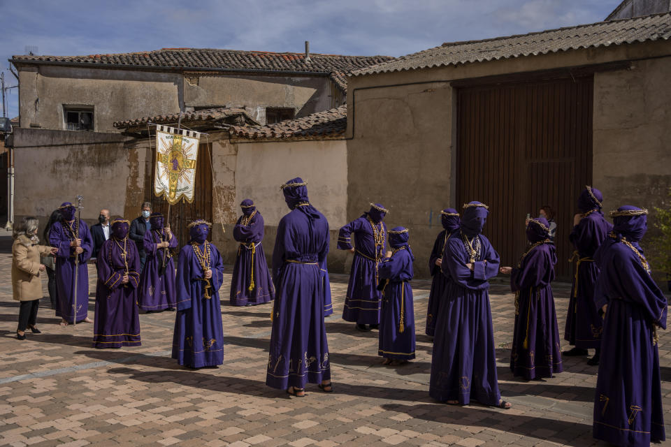 Penitentes de la Hermandad de Jesús Nazareno participan en una procesión en Fuentesauco, en el noroeste de España, el 14 de abril de 2022. (AP Foto/Bernat Armangué)