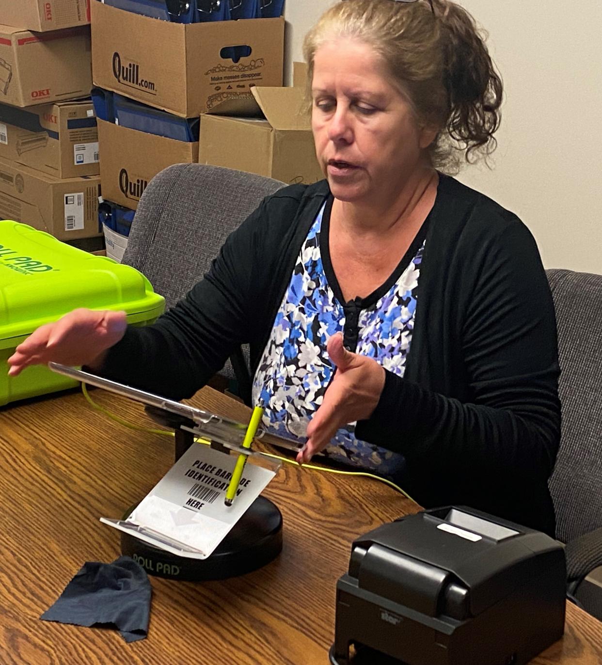Guernsey County Board of Elections Director Lori Bamfield works with one of the touch pads that poll workers will utilize to check in voters and have them sign for a ballot in a one-step process that will be utilized during the May 2022 Primary Election.
