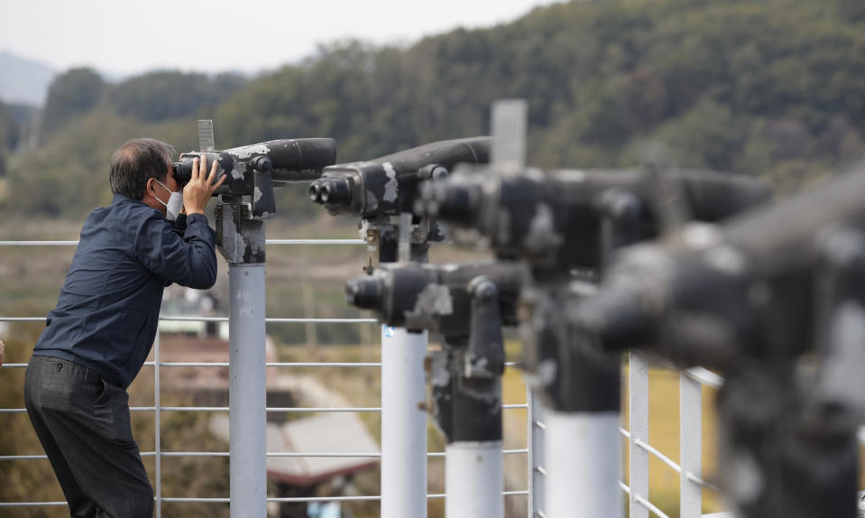 A man wearing a face mask uses binoculars to view from the Imjingak Pavilion in Paju, South Korea, Sunday, Oct. 11, 2020. North Korean leader Kim Jong Un warned that his country would "fully mobilize" its nuclear force if threatened as he took center stage at a military parade that unveiled what appeared to be a new intercontinental ballistic missile and other weapons Saturday. (AP Photo/Lee Jin-man)