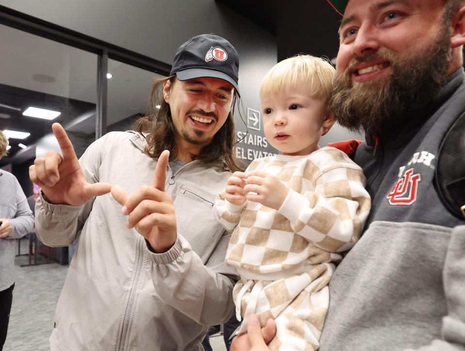 Utah Utes quarterback Cam Rising poses for a photo with Whitaker Fountain, 2, and his father Alan at a Crimson Collective truck giveaway to scholarship players at Rice-Eccles Stadium in Salt Lake City on Wednesday, Oct. 4, 2023. | Jeffrey D. Allred, Deseret News