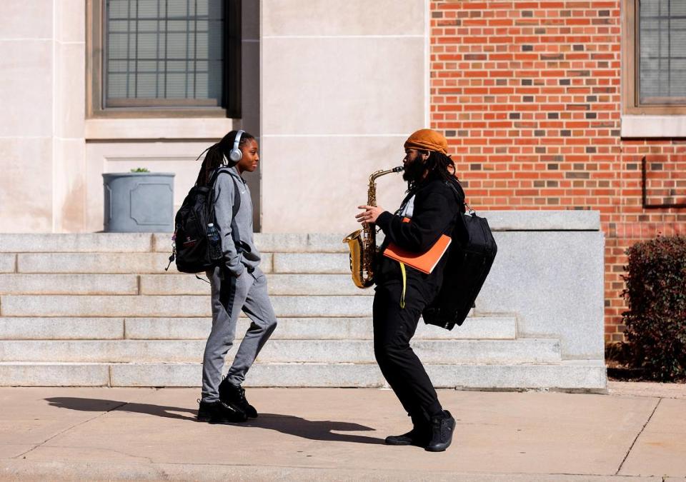 North Carolina Central University sophomore T’Jay Andrews, right, plays the saxophone while walking through campus on the way to band practice on Tuesday, March 12, 2024, in Durham, N.C.