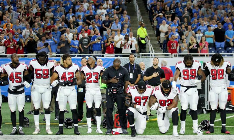 Members of the Atlanta Falcons football team Grady Jarrett and Dontari Poe take a knee during the playing of the national anthem.