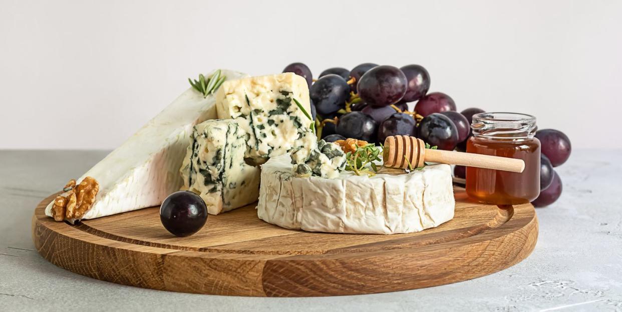 tasting brie, camembert, and roquefort on a wooden board