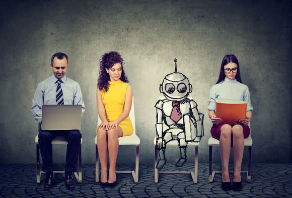 A robot sits with three human workers.