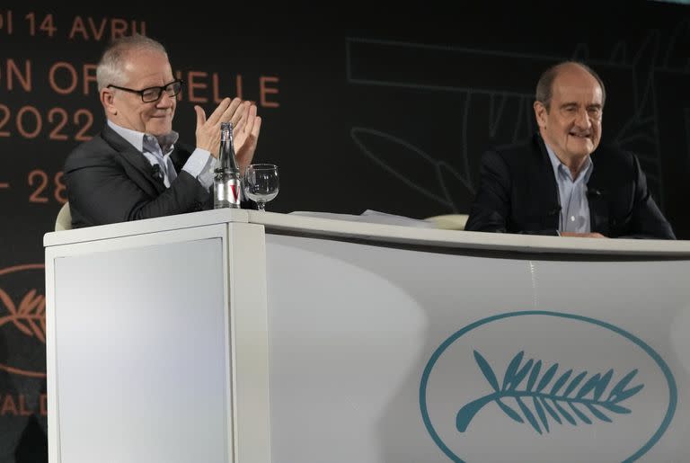 El delegado general del festival, Thierry Fremaux, a la izquierda, aplaude mientras el presidente del festival, Pierre Lescure, sonríe durante una conferencia de prensa para anunciar la programación del festival de cine de Cannes para la próxima edición 75 