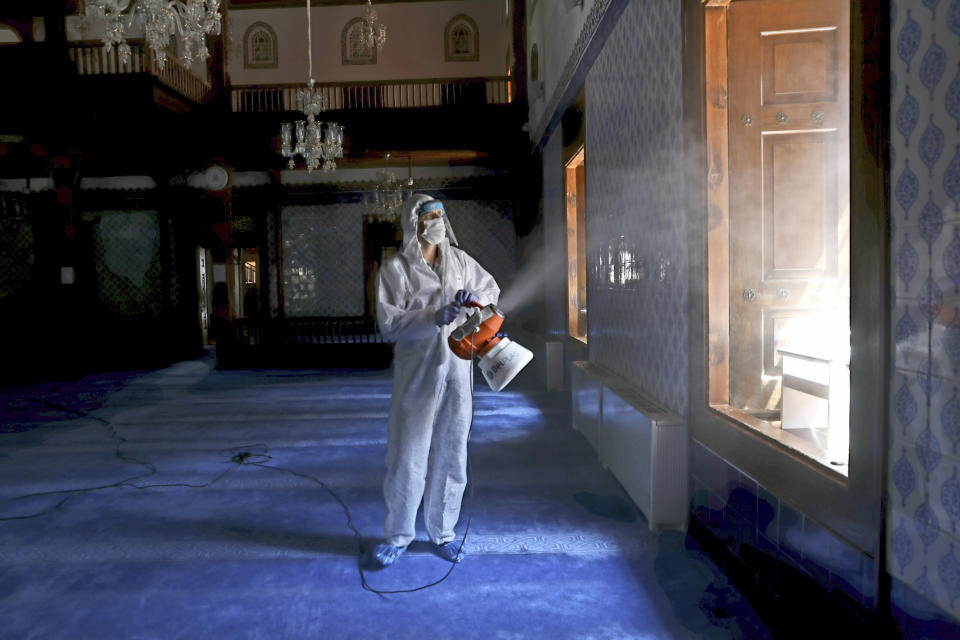 A Municipality worker disinfect the inside of historical Haci Bayram Mosque, in Ankara, Turkey, Thursday, May 28, 2020. Turkish authorities prepare mosques for communal prayers at limited capacity, observing social distancing rules, starting with Friday prayers since mosques shut down back in March; worshippers supposed to pray outside in mosque courtyards.( AP Photo/Ali Unal)