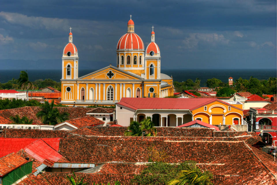 View from the bell tower of La Merced church, Granada, Nicaragua in the afternoon with the lake on the horizon, and the yellow cathedral dominating the colonial skyline.