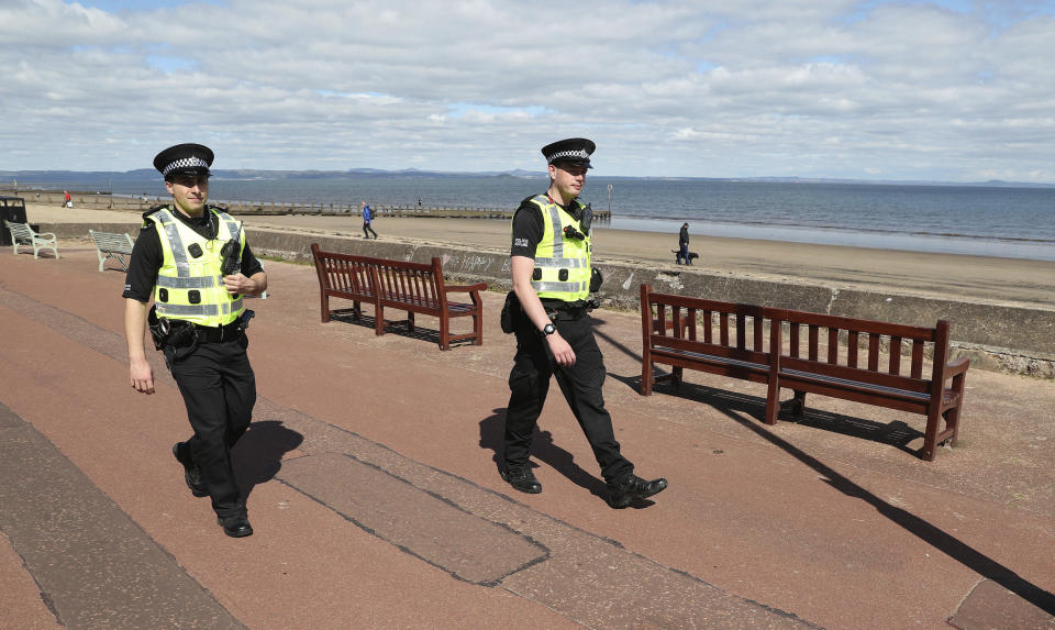 Police officers patrol the beach front at Portobello, in Edinburgh, Scotland,  as the UK continues in lockdown to help curb the spread of the coronavirus, Sunday April 26, 2020. The highly contagious COVID-19 coronavirus has impacted on nations around the globe, many imposing self isolation and exercising social distancing when people move from their homes. (Andrew Milligan / PA via AP)
