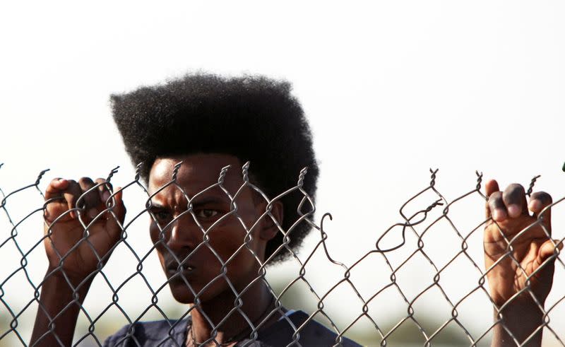 Ethiopians who fled war in Tigray region, looks through a wire fence as he arrives to receive relief supplies from the World Food Programme at the Fashaga camp on the Sudan-Ethiopia border in Al-Qadarif state