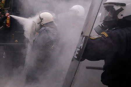 A protester uses a fire extinguisher against riot police during clashes outside the parliament building as Greek school teachers demonstrate against government plans to change hiring procedures in the public sector in Athens, Greece, January 14, 2019. REUTERS/Alkis Konstantinidis