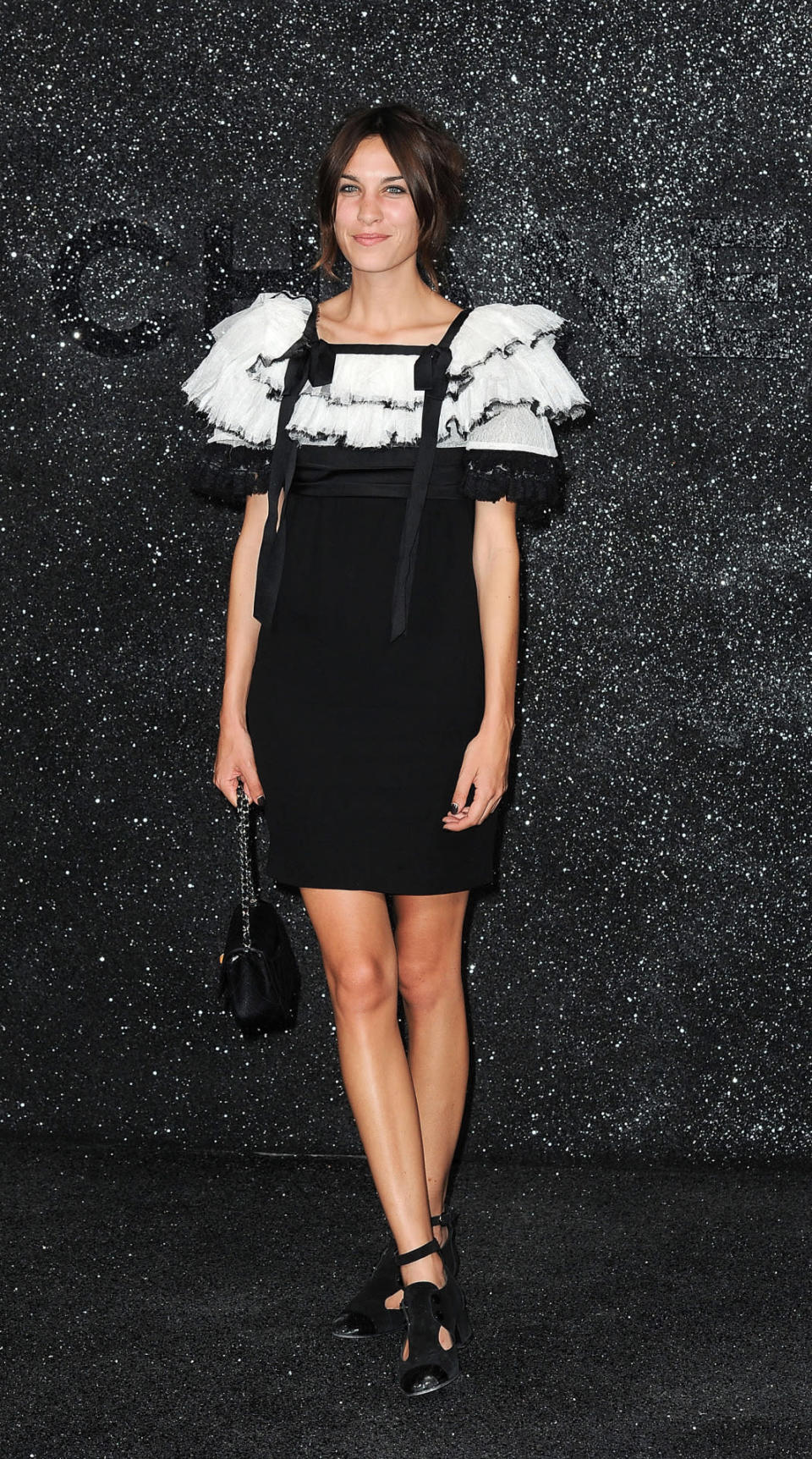 Le mannequin britannique Alexa Chung a opté pour une robe bi-matière imaginée par le créateur. La tenue joue avec les oppositions avec un haut blanc à volants et un bas noir près du corps. 
