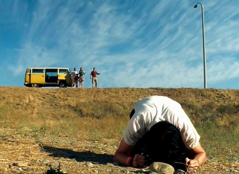 Dwayne with his head on the ground in sadness with the sky behind in