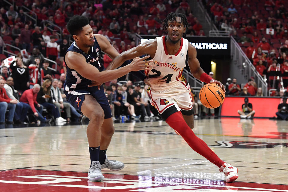 Louisville forward Jae'Lyn Withers (24) drives past Virginia forward Jayden Gardner during the second half of an NCAA college basketball game in Louisville, Ky., Wednesday, Feb. 15, 2023. Virginia won 61-58. (AP Photo/Timothy D. Easley)