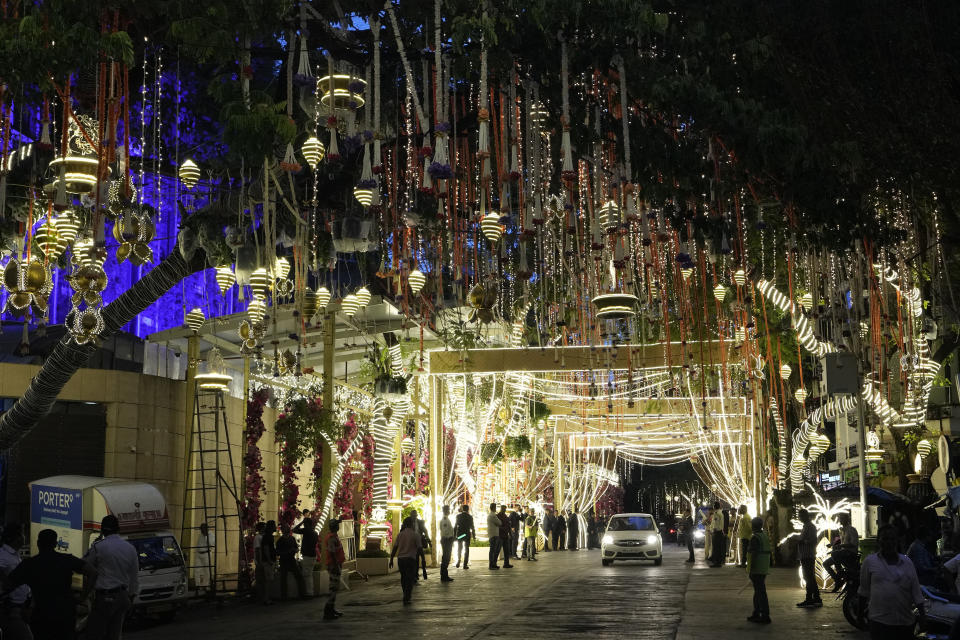 FILE - People walk past the Antilia mansion, house of billionaire Mukesh Ambani, while it is lit up ahead of his son Anant Ambani and Radhika Merchant's wedding in Mumbai, India, Wednesday, July 10, 2024. The youngest son of Mukesh Ambani, Asia’s richest man, has married his longtime girlfriend in what many have dubbed the wedding of the year. The wedding early Saturday was being attended by global celebrities, business tycoons and politicians, highlighting the billionaire’s staggering wealth and rising clout, and came after months of festivities.(AP Photo/Rajanish Kakade, File)