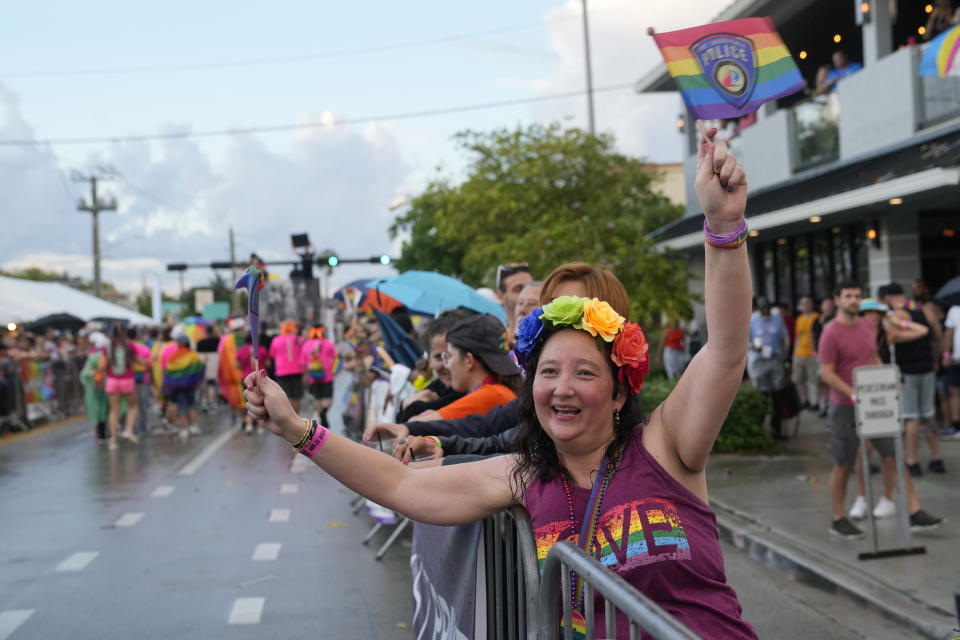 A spectator waves pride flags during the Stonewall Pride Parade and Street Festival, Saturday, June 17, 2023, in Wilton Manors, Fla. (AP Photo/Lynne Sladky)