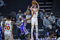 Atlanta Hawks guard Kevin Huerter (3) makes a 3-point basket against Sacramento Kings guard De'Aaron Fox (5) during the first quarter of an NBA basketball game in Sacramento, Calif., Wednesday, March 24, 2021. (AP Photo/Hector Amezcua)