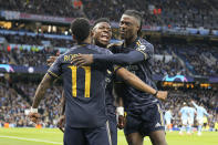 Real Madrid's Vinicius Junior, center, celebrates after his teammate Real Madrid's Rodrygo, left, scored his side's opening goal during the Champions League quarterfinal second leg soccer match between Manchester City and Real Madrid at the Etihad Stadium in Manchester, England, Wednesday, April 17, 2024. (AP Photo/Dave Shopland)