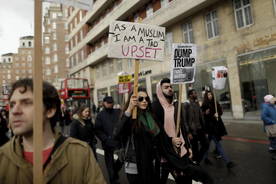People hold placards as they take part in a protest march in London, against U.S. President Donald Trump's ban on travellers and immigrants from seven predominantly Muslim countries entering the U.S., Saturday, Feb. 4, 2017. (AP Photo/Matt Dunham)