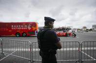 A police officer guards the parking of the cycling team busses prior to the eighteenth stage of the Tour de France cycling race over 129.7 kilometers (80.6 miles) with start in Pau and finish in Luz Ardiden, France,Thursday, July 15, 2021. The Bahrain Victorious team, rear, competing at the Tour de France says it was raided by French police on the eve of Thursday's stage. (AP Photo/Christophe Ena)