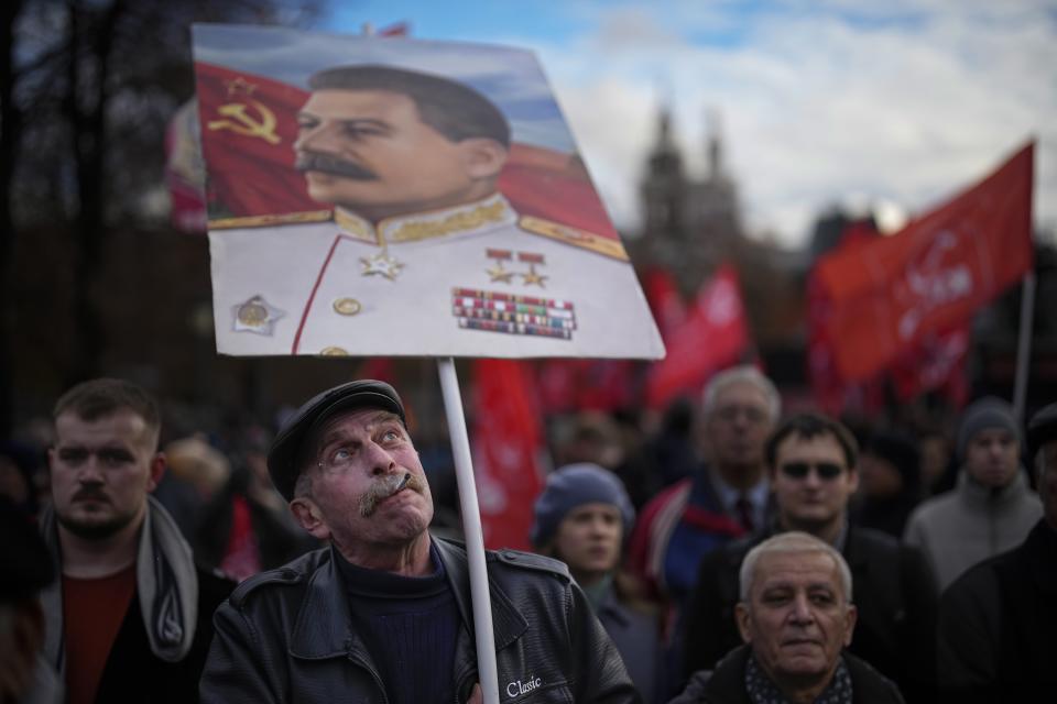 A communist party supporter holds a portrait of Soviet leader Josef Stalin during a demonstration near Red Square in Moscow, Russia, on Tuesday, Nov. 7, 2023, as they gather to mark the 106th anniversary of the 1917 Bolshevik revolution. (AP Photo/Alexander Zemlianichenko)