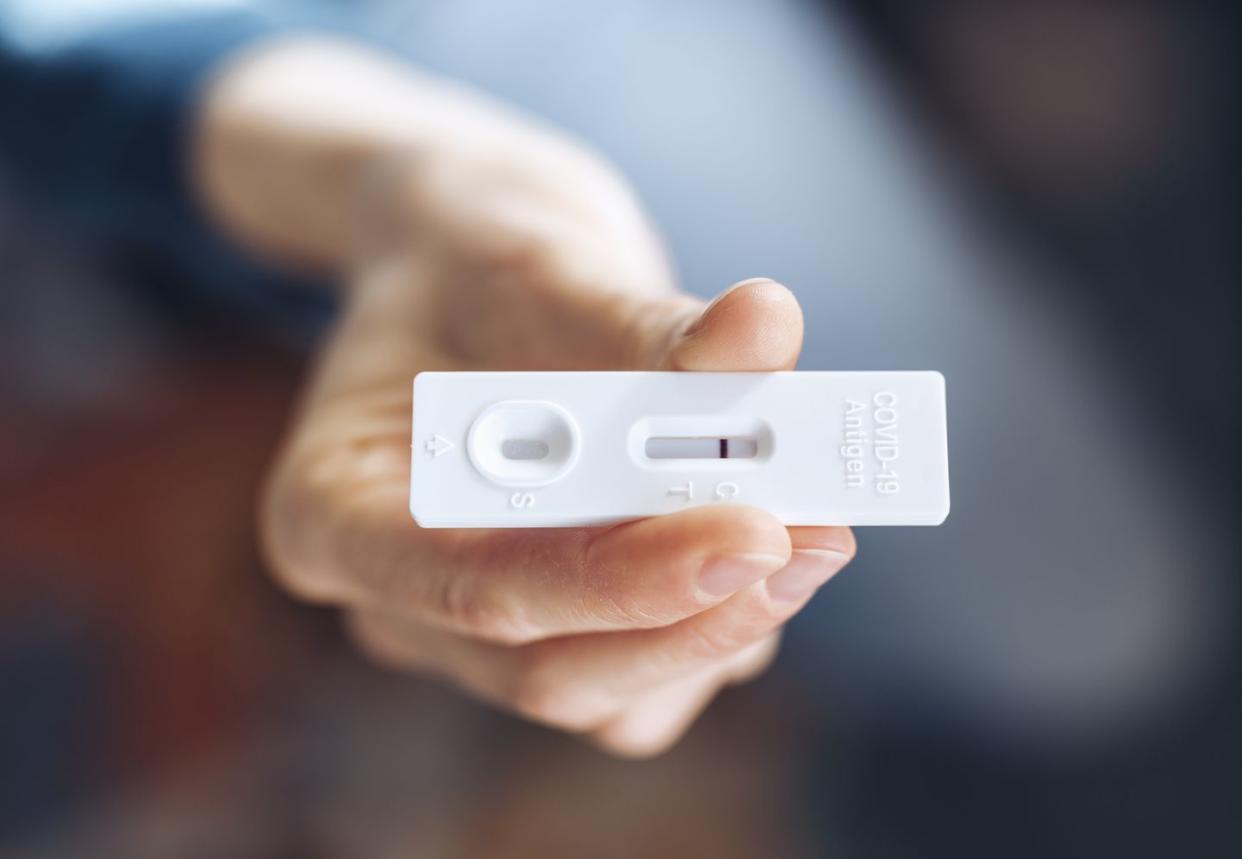 young not recognizable woman holding a coronavirus self test at home showing negative test result