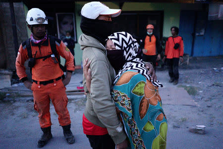 A woman cries after identifying the remains of a relative who died in an earthquake in the Balaroa neighbourhood in Palu, Central Sulawesi, Indonesia, October6, 2018. REUTERS/Athit Perawongmetha