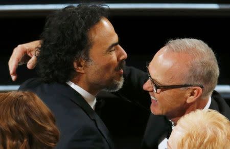 Director Alejandro Inarritu (L) embraces actor Edward Norton after their movie "Birdman" won the Oscar for best original screenplay at the 87th Academy Awards in Hollywood, California February 22, 2015. REUTERS/Mike Blake
