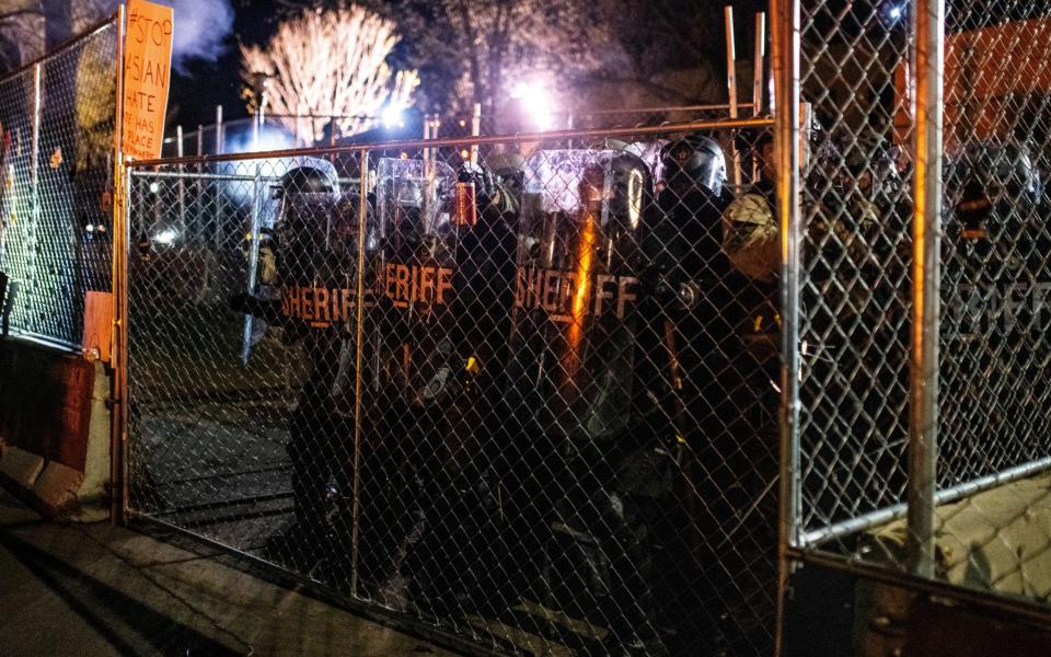 Law enforcement officers push up to a gate outside the Brooklyn Center police headquarter - Stephen Maturen /Getty