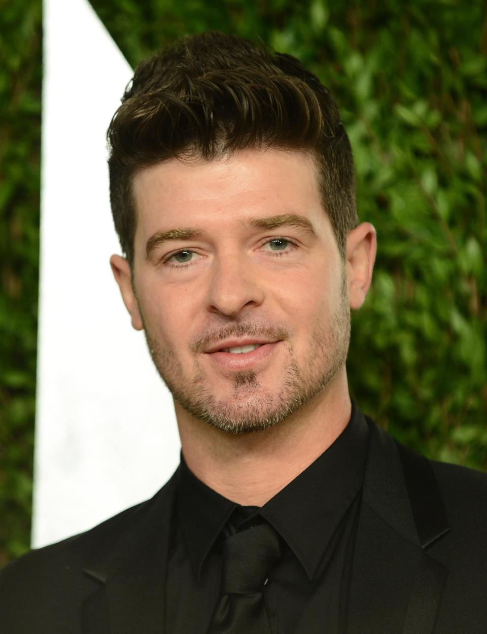 FILE - In this Feb. 24, 2013 file photo, Robin Thicke arrives at the 2013 Vanity Fair Oscars Viewing and After Party at the Sunset Plaza Hotel in West Hollywood, Calif. Thicke originally didn't plan to release the unrated version of his music video for the song “Blurred Lines,” which features nude models prowling around him and rappers Pharrell and T.I. (Photo by Jordan Strauss/Invision/AP, File)