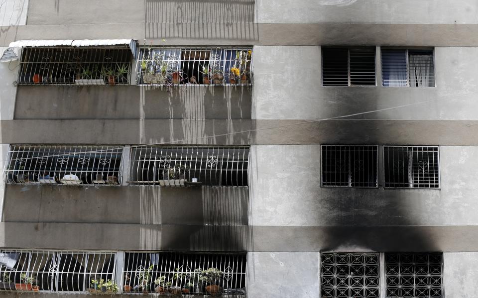 Signs of smoke cover the apartment complex where an allegedly armed drone crashed, causing a fire, in Caracas, Venezuela, Sunday, Aug. 5, 2018. Venezuelan President Nicolas Maduro dodged an apparent assassination attempt the previous day when drones armed with explosives detonated while he was delivering a speech to hundreds of soldiers being broadcast live on television, according to officials. (AP Photo/Ariana Cubillos)