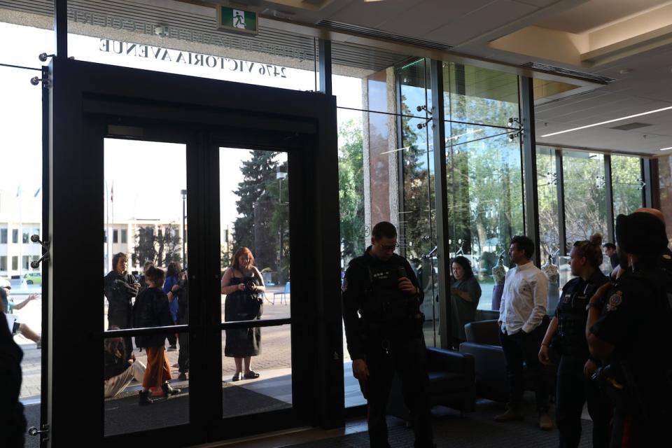 Members of the public were barred from Regina city hall at the direction of Mayor Sandra Masters after disruption at the city council meeting on June 21, 2023.  Organizers are seen outside the doors of city hall as police and Coun. Dan LeBlanc (White shirt) look on from inside the building. 