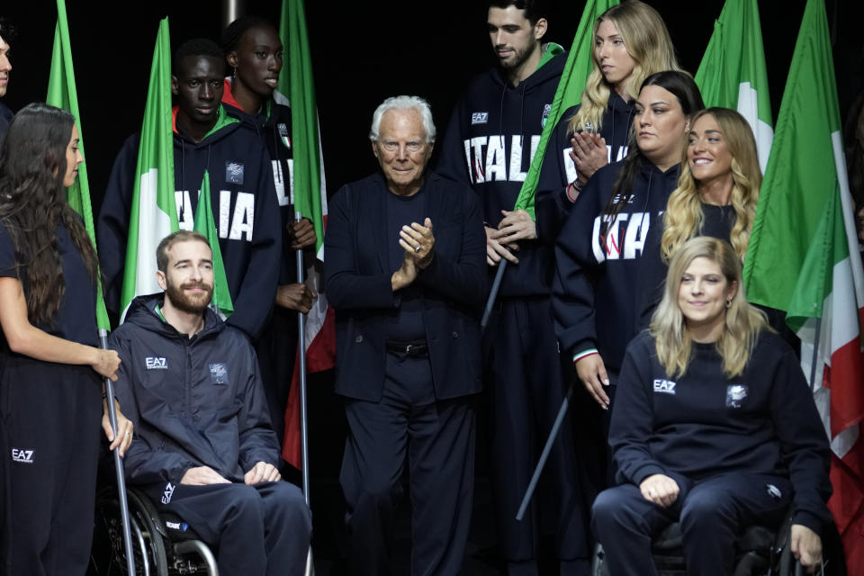 Designer Giorgio Armani accepts applause with Italy's Paralympic team at the end of the Emporio Armani men's Spring Summer 2024 collection presented in Milan, Italy, Saturday, June 17, 2023. (AP Photo/Luca Bruno)