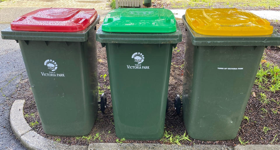 A photo of the green FOGO bin now available in Victoria Park, Perth, as well as the existing red general waste bin and yellow recycling bin.