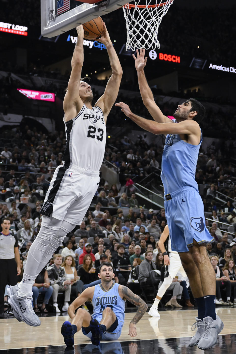 San Antonio Spurs' Zach Collins (23) dunks against Memphis Grizzlies' Santi Aldama during the first half of an NBA basketball game, Saturday, Nov. 18, 2023, in San Antonio. (AP Photo/Darren Abate)