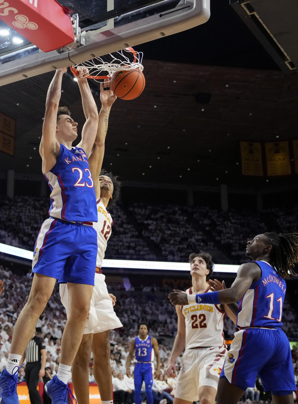 Kansas forward Parker Braun (23) scores as Iowa State forward Robert Jones (12) defends under the basket during the first half of an NCAA college basketball game, Saturday, Jan. 27, 2024, in Ames, Iowa. (AP Photo/Matthew Putney)