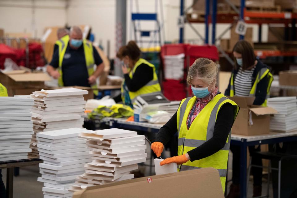 Workers and war veterans wearing PPE (personal protective equipment) of a face mask as a precautionary measure against COVID-19, social distance as they assemble and prepare for shipping commemorative "Tommy" figures at the Royal British Legion Industries (RBLI) BBMC (Britain's Bravest Manufacturing Company) factory in Aylesford, south east England on May 5, 2020, ahead of the 75th anniversary of VE day (Victory in Europe Day) marking the end on World War II on May 8. - Britons have been encouraged to mark the 75th anniversary of VE Day, even though all the country is still in lockdown due to the COVID-19 pandemic - the RBLI charity's "Tommy in the Window" campaign is one way in which people are able to show their support. Each purchase of one of the RBLI's commemorative military 'Tommy' figures assists with helping a veteran into employment or onto an employment course. (Photo by DANIEL LEAL-OLIVAS / AFP) (Photo by DANIEL LEAL-OLIVAS/AFP via Getty Images)