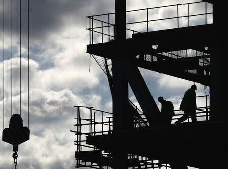 Workers are silhouetted on a construction site in London April 17, 2008. REUTERS/Luke MacGregor