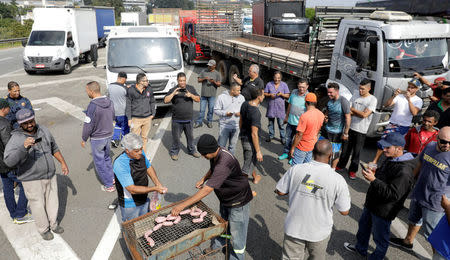 Truckers prepare a barbecue as they block the Imigrantes highway SP-160 during a protest against high diesel fuel prices in Sao Paulo, Brazil May 24, 2018. REUTERS/Paulo Whitaker