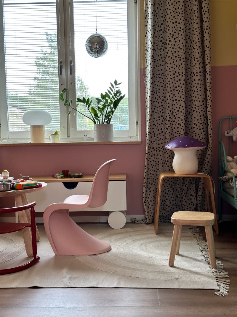 Pink dining chairs in a colorful room.