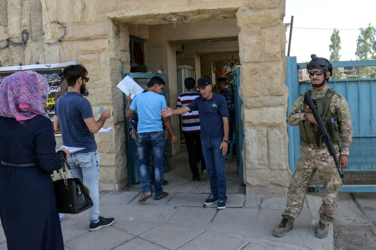 Iraqi students are searched outside the University of Mosul as they arrive to take their exams