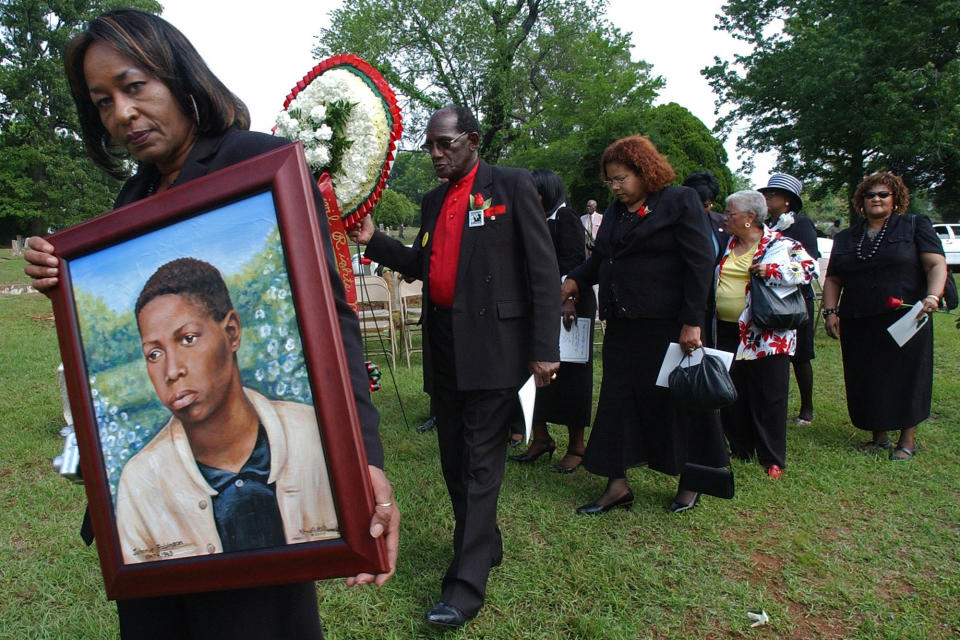 Shirley Peoples carries a portrait of Johnnie Robinson and leads a procession of family and others during a wreath laying ceremony in memory of Robinson on May 5, 2007, at New Grace Hill Cemetery in Birmingham, Ala.  (Bernard Troncale / The Birmingham News via AP file)